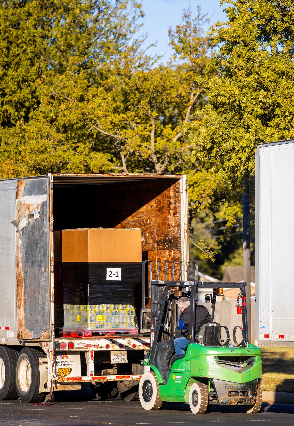 Forklift loading pallets onto a freight truck at a warehouse — Austria-Poland freight transport